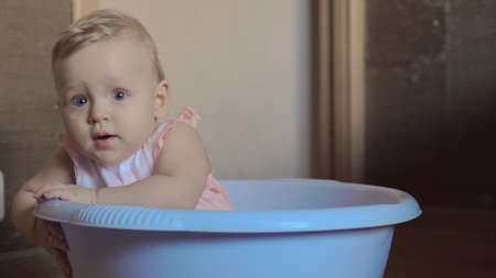 Cute baby girl in a round blue tub 2