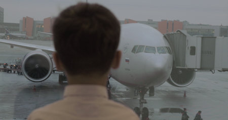 Child looking at airplane before boarding in Sheremetyevo Airport, Moscowのeditorial素材