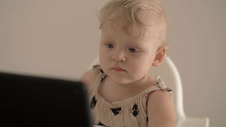 Little girl watching cartoons on tablet computer at homeの写真素材