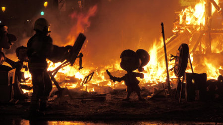 Firefighter burning ninots in the fire of La Cream on Fallas celebration, Spainのeditorial素材