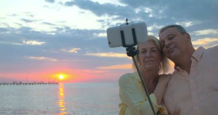 Couple on vacation taking selfie at sunsetの写真素材
