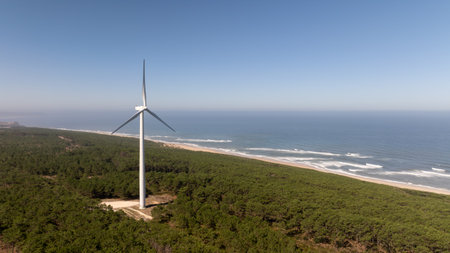 Wind turbine generating clean energy in a coastal forest near the atlantic ocean in Nazare,...