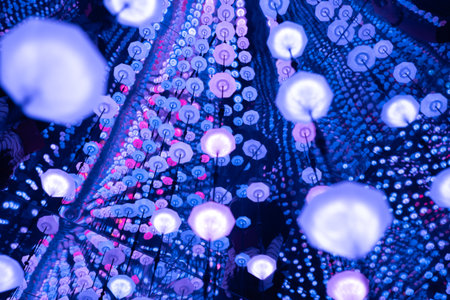 Umbrella shaped LED lights suspended from ceiling, casting vibrant, kaleidoscopic illumination across interior spaceの写真素材