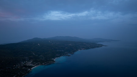 Aerial view of the coastline of Sithonia, Greece, during the blue hour, with dark mountains and calm seaの写真素材