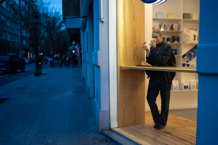 Woman standing by a window while enjoying a coffee in a modern cafe in the evening