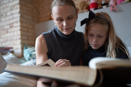 Woman and young girl reading a book in a cozy room with soft lighting and warm atmosphere