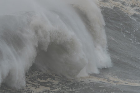 Extreme close up of a massive wall of water and sea foam crashing down in the stormy atlantic oceanの写真素材