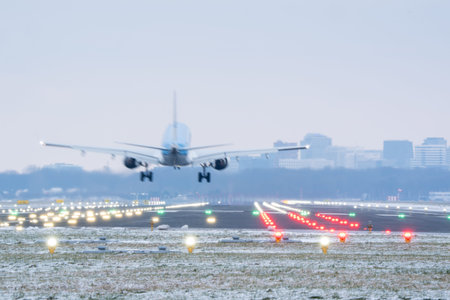 Back view of passenger jet descending to runway during cold winter morning