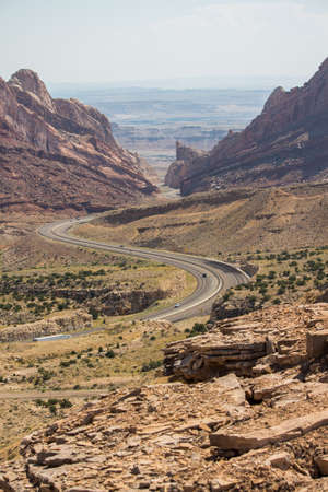 A desert highway winds through steep rock walls.
