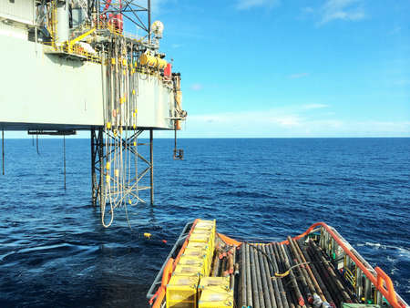 Oil platform during cargo loading with offshore vessel