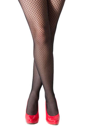 A dancers legs in fishnet stockings and red heels isolated on whiteの写真素材