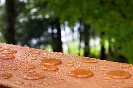 Water beads on the freshly treated deck rail, after a summer rain at the summer cottageの写真素材