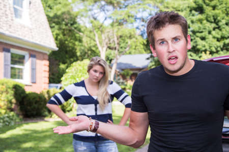 A young man shows frustration in an argument with his girlfriendの写真素材
