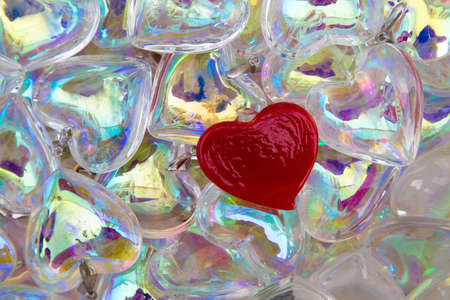 one red heart in a whole sea of translucent clear glass ones. Symbol of one true love, or being different and standing outの写真素材