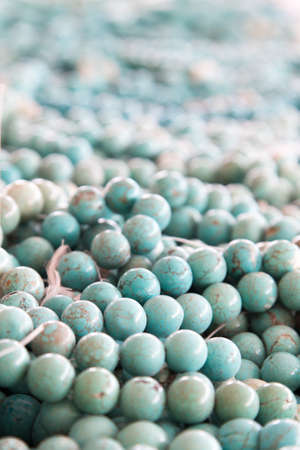 a large quantity of turquoise beads fill the frame fading of softly to make good backdrop for copyの写真素材