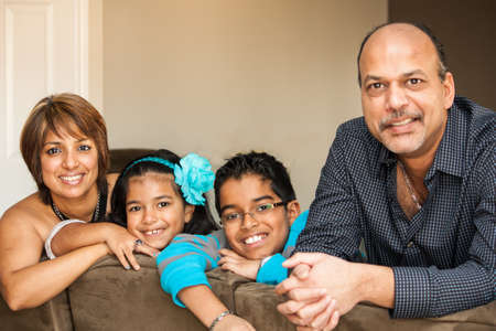 Family of Indian Origin smiling and looking at camera