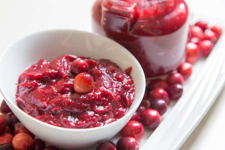 a dish and a jar of home made cranberry relish to pair with a holiday turkey or hamの写真素材