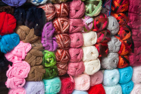 Ecuador is filled with hand made textiles made from balls of colorful wool like these ones stacked up in a wool shopの写真素材
