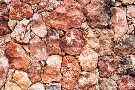 local red lava rock is crafted into a tightly fitted stone wall