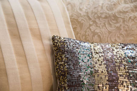 a variety of luxury decor cushions in beige and champagne tones with a little bling