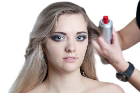 head portrait of a young woman having her hairs set by a hairdresser isolated on whiteの写真素材