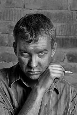 dramatic view of a man sick of smoking cigaretteの写真素材