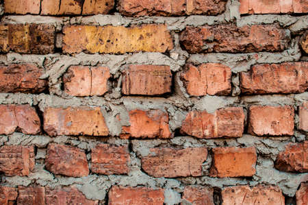 Texture of old red brickwork with rough cement layers