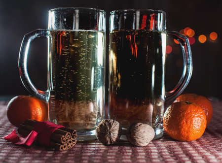 New Year's eve. Funny image of two beer glasses of champagne, mandarins, cinnamon and walnuts on the...