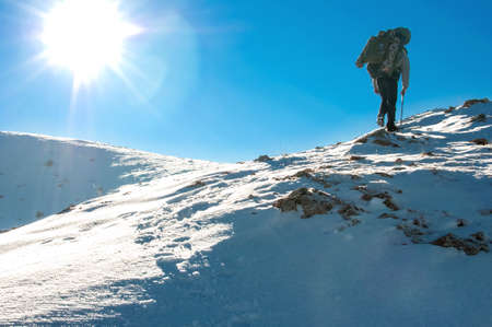Hiker climbs to the top of Chatyr Dag mountain in the Crimean mountains. Graphically image with clear blue sky and white showy slope.の写真素材