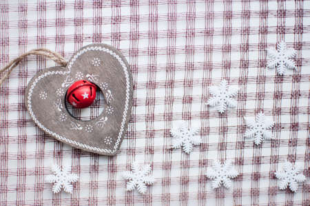 White christmas snowflakes and wooden heart decoration on checkered pink background. Vintage winter wallpaper. Flat lay, top viewの写真素材