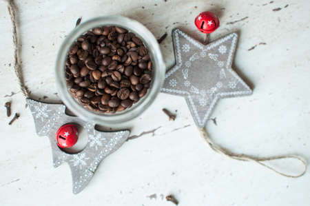 Wooden Christmas toys on the table. Tree, star, coffee beans in jar and spices. Flat lay, top view. Rustic Christmas background.の写真素材