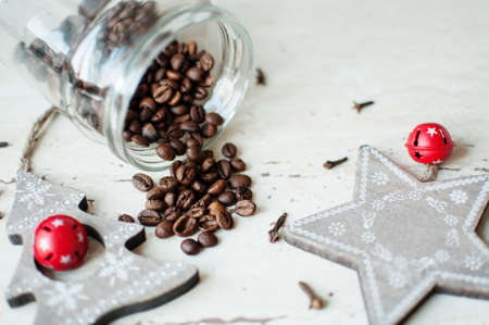 Wooden Christmas toys on the table. Tree, star, cloves and spilled coffee beans from a jar. Top view. Rustic Christmas background.の写真素材