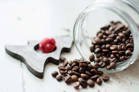 Wooden Christmas toy and coffee beans on the table. Tree, cloves and spilled coffee beans from a...