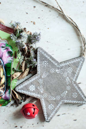 Wooden Christmas toy and spices on the table. Wooden star, dry mint, cardamom and cloves. Flat lay, top view, close up. Rustic Christmas background.の写真素材