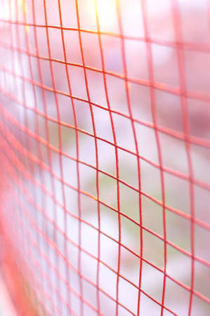 Red metallic cage background with blurred bokeh backdrop.の写真素材
