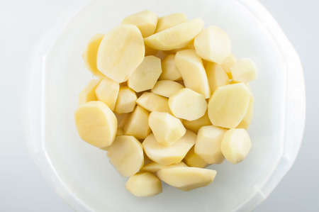 Sliced, peeled raw potatoes in a deep bowlの写真素材