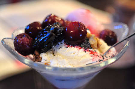 Fruit ice cream with cherries and prunes at a cafe.の写真素材