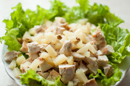 Hawaiian salad. Mixed ingredients in the plate. Chopped ruddy chicken breasts with leaf salad, pieces of pineapple and crushed walnut.の写真素材