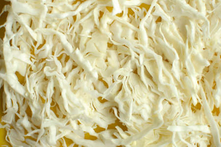 Sliced white cabbage on a yellow cutting board close up. Selective focus.の写真素材