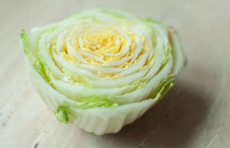 Cut Chinese cabbage stalk on a wooden table. Top view, soft selective focus. Abstract background.の写真素材