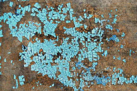 Rustic hardboard texture with scratches, cracks and blue peeling paint. Grunge texture or background