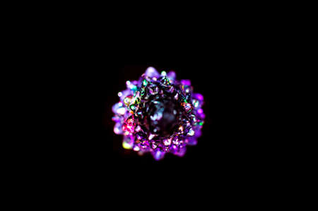 A small lighting colorful Christmas tree on the black background. Selective focus, top view. Abstract colorful Christmas background.の写真素材