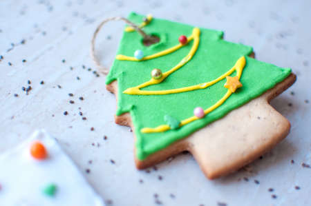 Two gingerbread cookies in the shape of the green and white Christmas tree on the background of a...