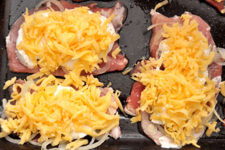 Raw pork chops on a black baking tray. Process of cooking step by step. Top view, flat lay.の写真素材