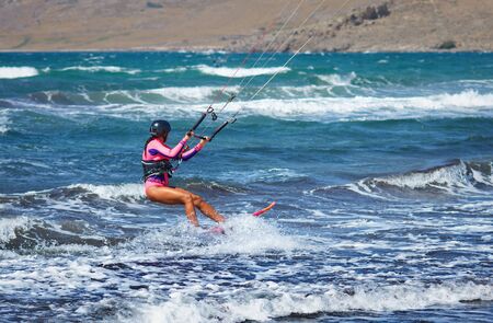 man kiteboarder kitesurfing unhooked at sunset and jumping rotations  athlete jump boy