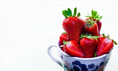 A cup of red strawberries for breakfast on white background. Eating red strawberries helps you live better by giving vitaminsの写真素材
