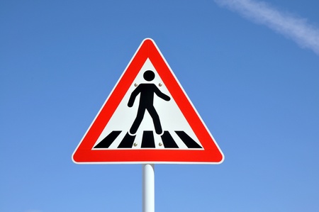 Pedestrian crossing sign on blue sky background