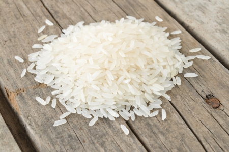 Raw rice on wooden table の写真素材