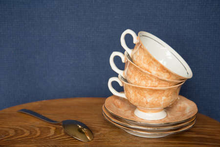 empty ceramic coffee cups on wooden table with blue backgroundの写真素材