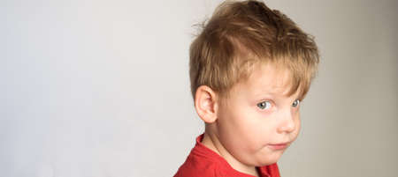 Little boy in red t-shirt is curious about something